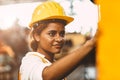 Happy African American woman worker with safety suit helmet enjoy smiling working as labor in heavy industry factory with steel Royalty Free Stock Photo