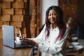 Happy african american woman worker using laptop work study at computer in loft office or cafe, smiling mixed race female student Royalty Free Stock Photo