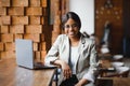 Happy african american woman worker using laptop work study at computer in loft office or cafe, smiling mixed race female student Royalty Free Stock Photo