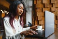 Happy african american woman worker using laptop work study at computer in loft office or cafe, smiling mixed race female student Royalty Free Stock Photo