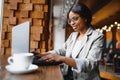 Happy african american woman worker using laptop work study at computer in loft office or cafe, smiling mixed race female student Royalty Free Stock Photo