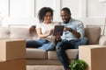Black couple relax on couch with tablet on moving day Royalty Free Stock Photo