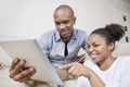 Happy African American young couple using digital tablet at home Royalty Free Stock Photo