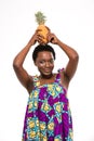 Happy african american young woman holding pineapple on her head Royalty Free Stock Photo