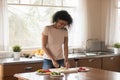 Happy african american young woman preparing romantic dinner in kitchen. Royalty Free Stock Photo