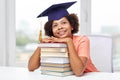 Happy african bachelor girl with books at home