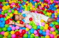 Happy african black boy playing in ball pit on birthday party in kids amusement park and indoor play center. Child Royalty Free Stock Photo