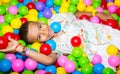 Happy african black boy playing in ball pit on birthday party in kids amusement park and indoor play center. Child Royalty Free Stock Photo