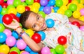 Happy african black boy playing in ball pit on birthday party in kids amusement park and indoor play center. Child Royalty Free Stock Photo