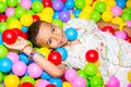 Happy african black boy playing in ball pit on birthday party in kids amusement park and indoor play center. Child Royalty Free Stock Photo