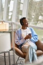 Happy African Black gen z girl wearing headphones using phone, vertical. Royalty Free Stock Photo