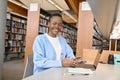 Happy African girl student using mobile phone in university library. Portrait Royalty Free Stock Photo