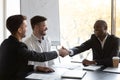 Happy African businessman shake hands with European business partner