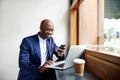 Happy african businessman using phone at cafe Royalty Free Stock Photo