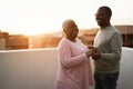 Happy african couple dancing outdoors at summer sunset - Focus on man face Royalty Free Stock Photo
