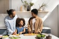 Happy African couple of parents teaching daughter kid to cook Royalty Free Stock Photo