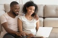 Happy african couple using laptop watching movie sit on floor Royalty Free Stock Photo