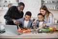 Happy african cute little sons and their young parents having online cooking class on laptop Royalty Free Stock Photo