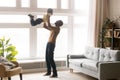 Happy african dad lifting little toddler son playing at home Royalty Free Stock Photo