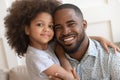 Happy african daddy and small cute child daughter embracing, portrait