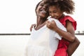 Happy African family on the beach during summer holidays - Afro American people having fun on vacation time