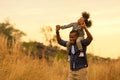 Happy African family child daughter riding the neck father and running on meadow Royalty Free Stock Photo