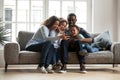 Happy african family with 2 children having fun with gadget