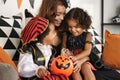 Happy african family in costumes celebrating Halloween holiday together at home Royalty Free Stock Photo