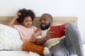 Happy African family, father and son spending time together, young boy with black curly hair and dad reading a book together while Royalty Free Stock Photo