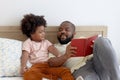 Happy African family, father and son spending time together, young boy with black curly hair and dad reading a book together while Royalty Free Stock Photo