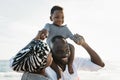 Happy African family having fun on the beach during summer holidays - Parents love concept