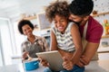 Happy african family having fun with device at home, black parents and child using digital tablet Royalty Free Stock Photo