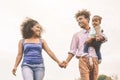 Happy African family having fun in public park - Father mother and little daughter enjoying time outdoor and laughing together Royalty Free Stock Photo