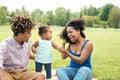 Happy African family having fun in public park - Mother and father with their daughter enjoying time together during weekend Royalty Free Stock Photo