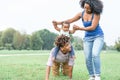 Happy african family having fun in a public park outdoor - Mother and father playing with their daughter during a weekend Royalty Free Stock Photo