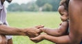 Happy african family holdings hands together outdoor during mother day - Mom, father and daughter having tender moments in nature Royalty Free Stock Photo