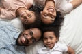Happy african family looking at camera on bed, top view Royalty Free Stock Photo