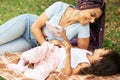 Happy african family mom and daughter have fun in the park, lie on the grass, spend time together, happiness and love Royalty Free Stock Photo