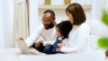 Happy african family parents and little children enjoy using computer laptop together sit on sofa Royalty Free Stock Photo