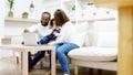 Happy african family parents and little children enjoy using computer laptop together sit on sofa Royalty Free Stock Photo