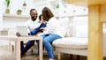 Happy african family parents and little children enjoy using computer laptop together sit on sofa Royalty Free Stock Photo