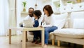 Happy african family parents and little children enjoy using computer laptop together sit on sofa Royalty Free Stock Photo