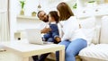 Happy african family parents and little children enjoy using computer laptop together sit on sofa Royalty Free Stock Photo