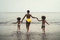 Happy African family running on the beach during summer holidays - Afro American people having fun on vacation time