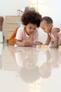 Happy African family spending time together, brother boy with black curly hair lying on floor, playing toy with little cute toddle Royalty Free Stock Photo