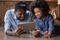 Happy African family using digital computer tablet. Royalty Free Stock Photo
