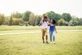 Happy African family walking together in public park - Mother father and baby daughter having fun spending time together outdoor Royalty Free Stock Photo