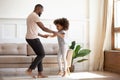 Happy african father and kid daughter jump dance at home Royalty Free Stock Photo