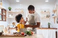 Happy African father and son dress up together before cooking in the white kitchen. Eye Contact, Relationship, Talking, Warm