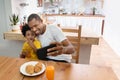 Happy African Father and son taking selfie photo with smartphone during lunch time in dining and kitchen room. Portrait smiling Royalty Free Stock Photo